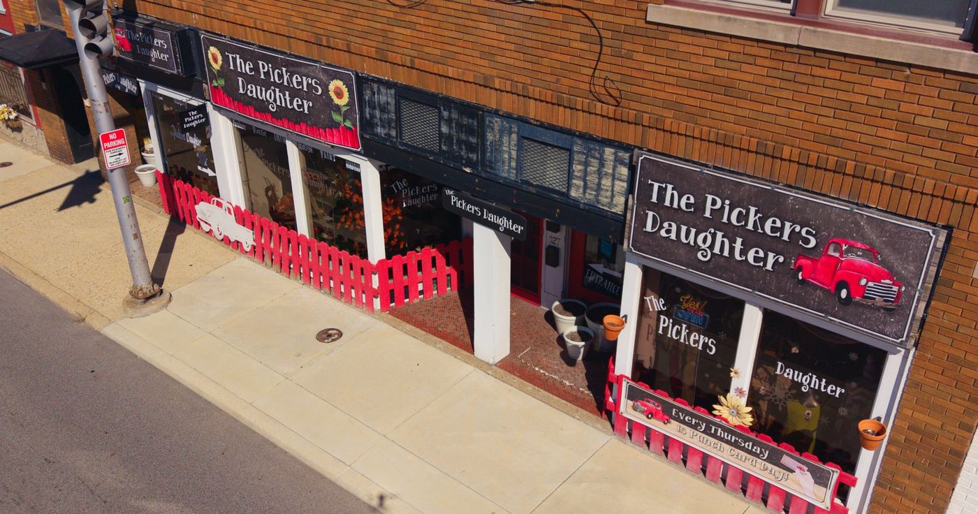 Aerial view of a local small-town storefront with red picket fence and painted signs